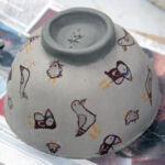 Slip cast bowl decorated with screen printed transfers. Ready for firing.